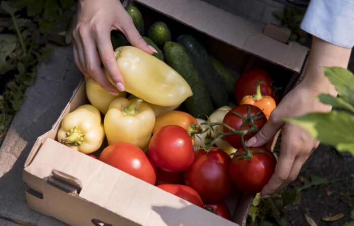 Photo of woman placing bulk produce in a box.