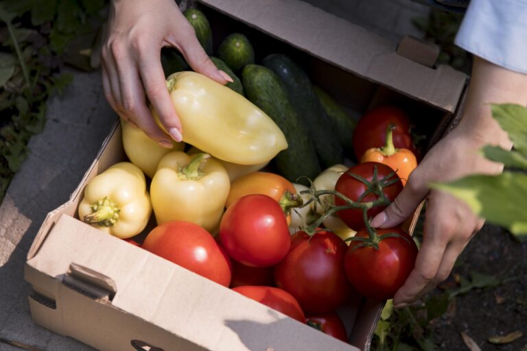 Photo of woman placing bulk produce in a box.