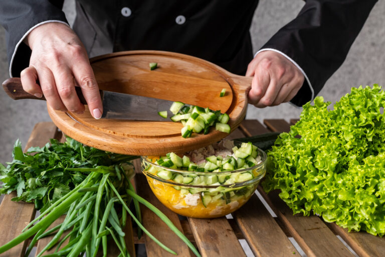 2148491238 Chef preparing Mediterranean salad with Persian cucumbers