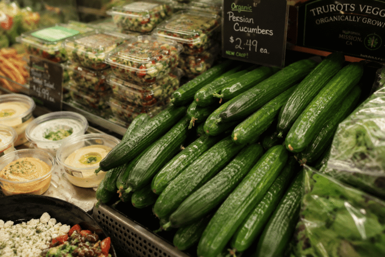 Produce display promoting Persian cucumbers in a grocery store