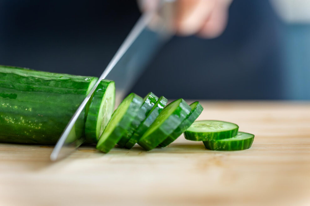 Chef preparing Persian cucumbers for a fresh salad program